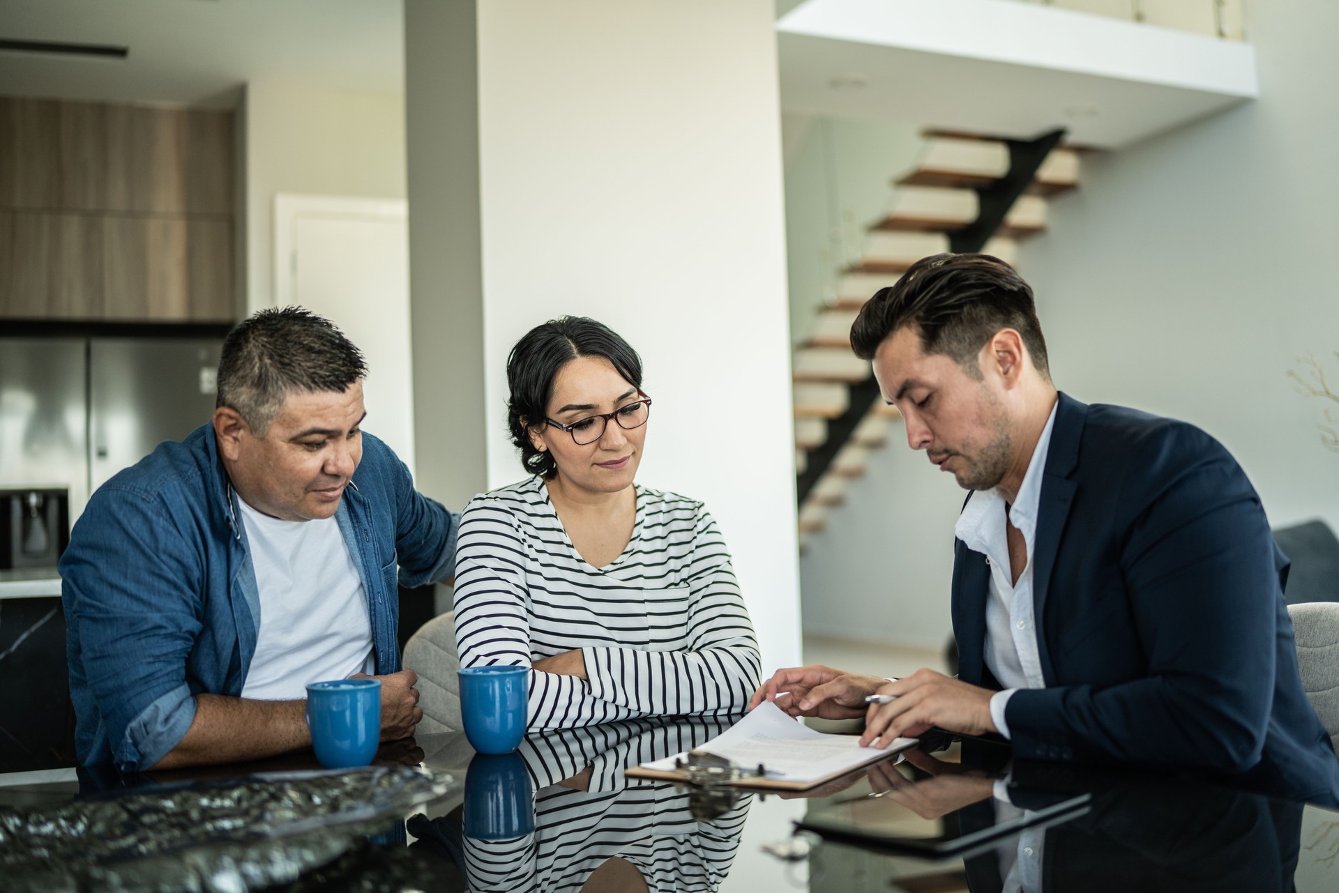 Financial advisor doing a meeting with a mid adult couple at home